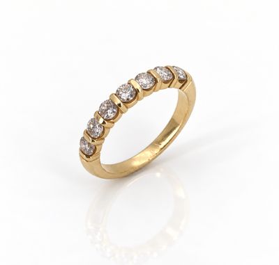 une bague en or jaune sertie de cinq diamants ronds sur fond blanc