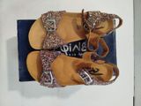 pair of children ' s sandals with glitter on them sitting on top of a blue box