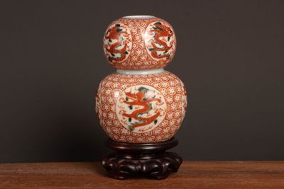 a vase that has a dragon on it on a table