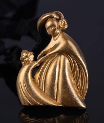 un pendentif en or représentant une femme tenant un enfant dans ses bras, sur un fond noir