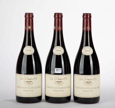 three bottles of red wine sitting next to each other on a table