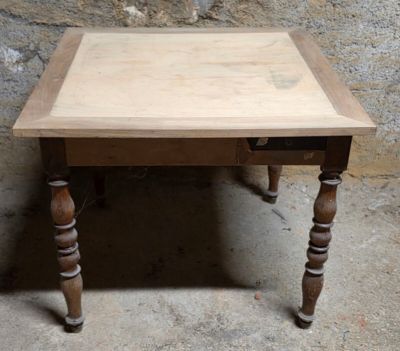 une petite table avec un plateau en bois sur un sol en ciment