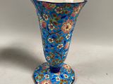 une image représentant un vase bleu posé sur une table blanche
