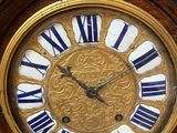 a gold clock with blue and white roman numerals on it