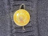 grey sweater with a gold button in the middle of it