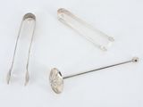 a silver spoon, spoon and spoon rest on a white surface
