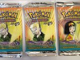 three packs of pokemon trading cards on a white surface