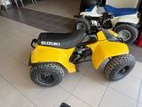a yellow four wheeler atv parked in a showroom