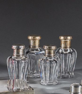 cinq petites bouteilles en verre avec des bouchons argentés posées sur une table