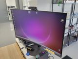 a computer monitor sitting on a desk with a keyboard