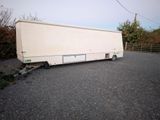 a white trailer that is parked on the side of the road