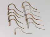 six pairs of metal hooks are arranged in a row on a white surface
