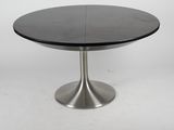 une table noire avec un piètement en métal sur fond blanc