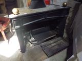 un vieux poêle dans un coin d'une pièce où se trouve une chaise