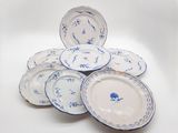 une pile d'assiettes bleues et blanches posées sur une surface blanche