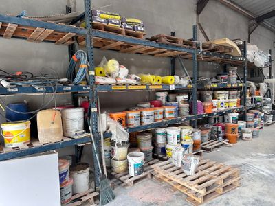 de nombreuses étagères remplies de peinture et d'autres articles dans un entrepôt