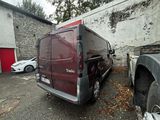 a red van parked in a parking lot next to a building