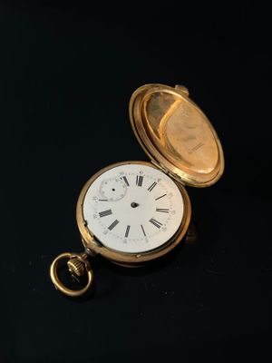 a gold pocket watch with roman numerals on it