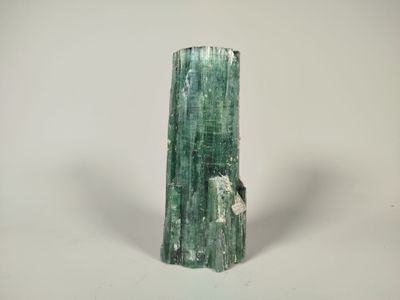a close up of a green piece of rock on a white surface