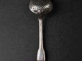 silver spoon on a black surface with a black background