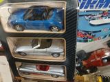 une petite voiture bleue dans une vitrine avec d'autres petites voitures