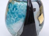 a blue vase with a black handle on a white surface