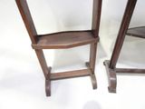 two wooden chairs sitting next to each other on a white surface