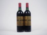 deux bouteilles de vin posées l'une à côté de l'autre sur une surface blanche