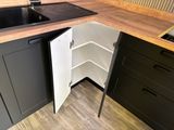 a kitchen with a sink and black cabinets and a wooden counter top