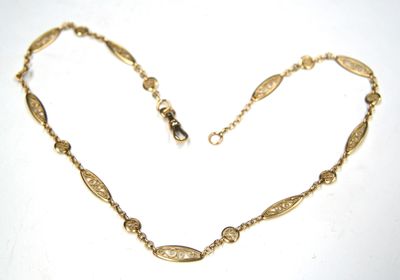 an image of a gold necklace on a white surface
