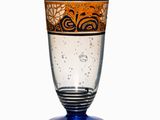 a glass with a design on it sitting on a table