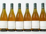 six bouteilles de vin sont alignées sur une table