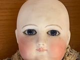 a close up of a doll on a wooden table