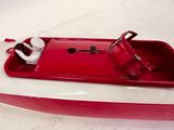 a red and white boat that is sitting on the floor