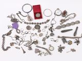 a lot of silver jewelry on a white surface