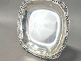 une assiette en argent antique avec un motif décoratif sur le bord