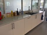 une cuisine avec un évier et un plan de travail sur lequel sont posées de nombreuses bouteilles