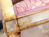 a wooden chair with a pink cushion on top of it
