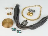 Plusieurs bijoux sont disposés sur une surface blanche