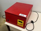 La boîte rouge est posée sur la table, à côté du chargeur.