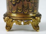 a gold and black vase sitting on top of a table