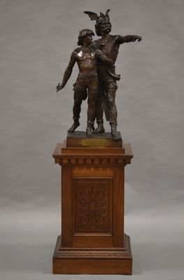 statue en bronze représentant un garçon et une fille sur un socle