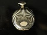 an antique silver pocket watch on a table with a black background