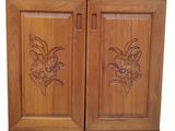 an image of a wooden cabinet with carved flowers on the doors