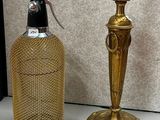 une lampe de table dorée posée à côté d'une bouteille sur une table