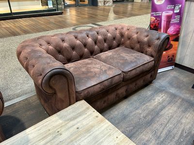 un canapé en cuir marron assis dans une pièce avec une table basse