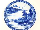 a blue and white plate with a landscape on it