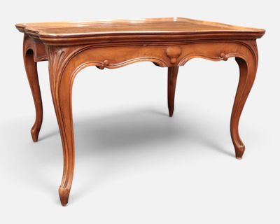 an old wooden table with a carved top and legs