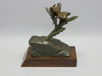 sculpture en bronze représentant une fleur posée sur un rocher, sur fond blanc