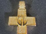 un gros plan d'une croix en or posée sur un tissu noir
